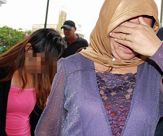 ANGGOTA Polis membawa dua suspek yang ditahan dipercayai telah menculik seorang bayi berusia tujuh bulan di Jalan Air Itam pada Khamis lalu ke Ibu Pejabat Polis Daerah (IPD) Timur Laut untuk siasatan lanjut. - Foto Muhammad Mikail Ong